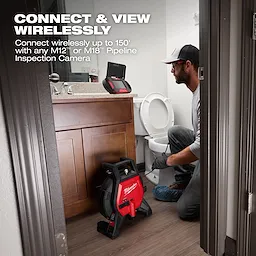 A person is kneeling in a bathroom beside a toilet, working with a Milwaukee pipeline inspection camera. The camera equipment is on the floor, and a monitor is on the sink. Text on the image advertises wireless connection up to 150 feet with M12 or M18 pipeline inspection cameras.