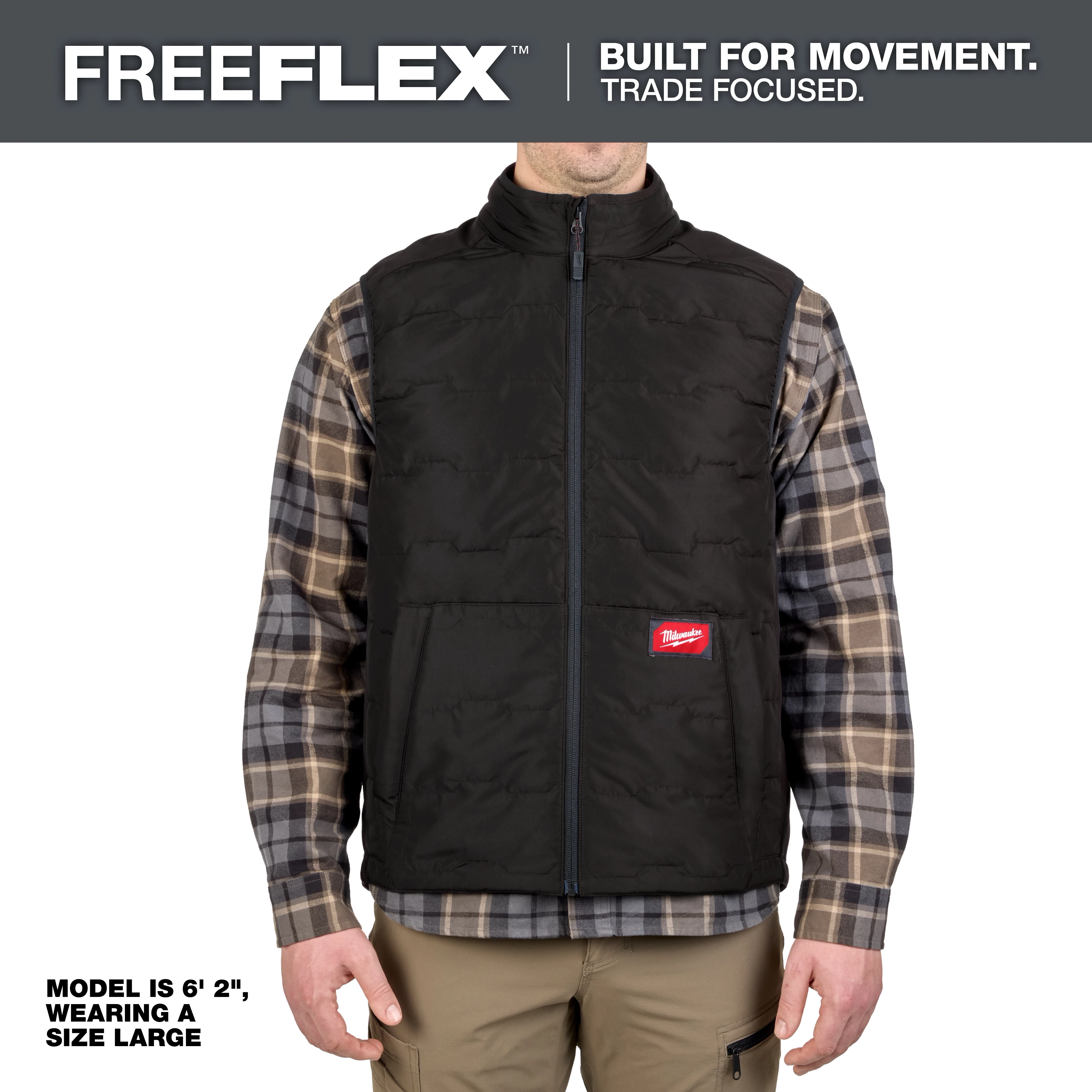 FreeFlex™ Lightweight Insulated Vest Black shown on a model wearing a size large. The vest features a front zipper, Milwaukee logo, and is worn over a plaid shirt with beige pants. The product emphasizes mobility and durability for tradespeople.