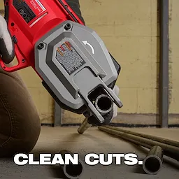 A person using a red and grey power tool is cutting a metal pipe indoors. The text "CLEAN CUTS." is displayed at the bottom. More metal pipes are lying on the floor in the background.