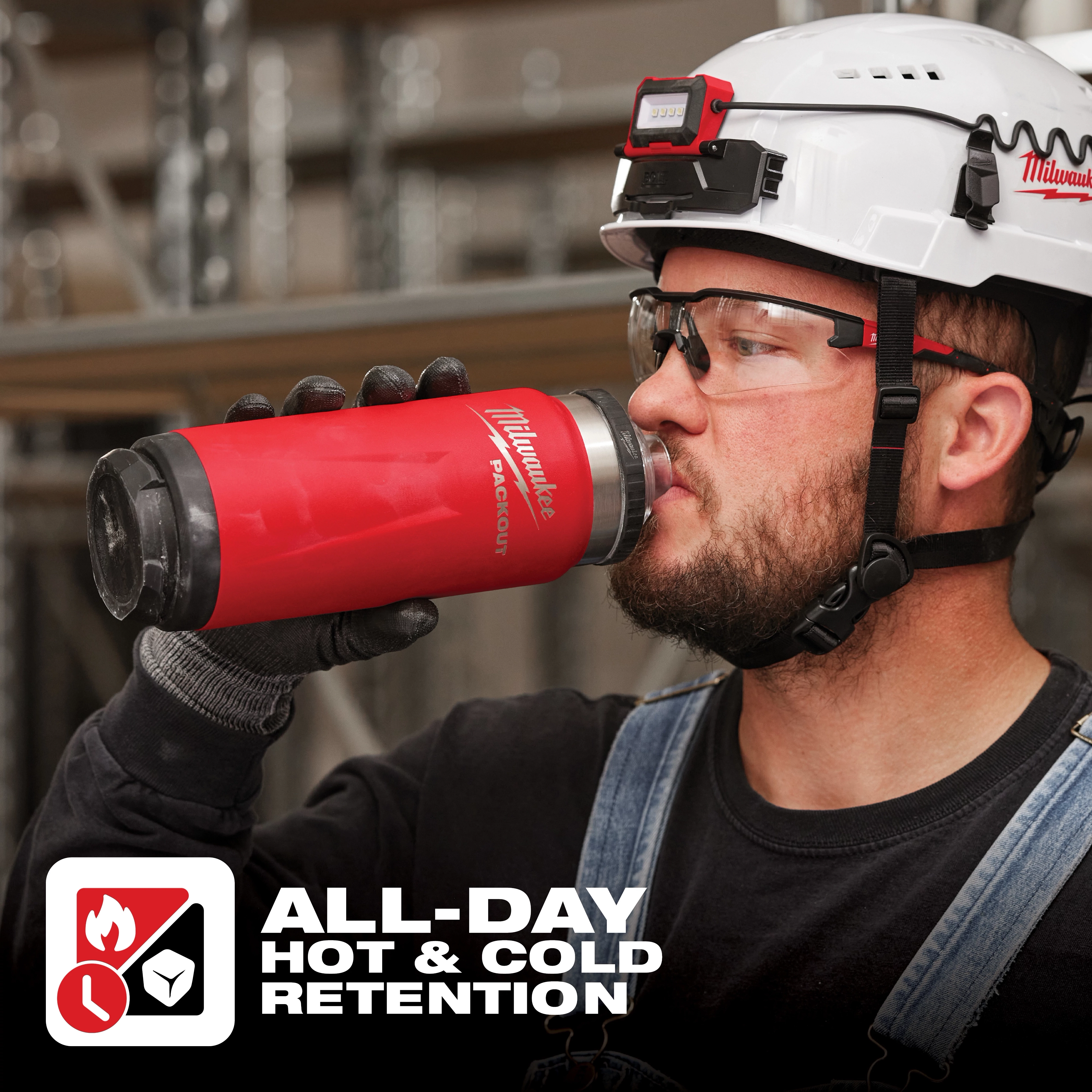Person wearing a white hard hat holding a red and black insulated bottle labeled "App%20Shot%20Overlay" with "All-Day Hot & Cold Retention" text.