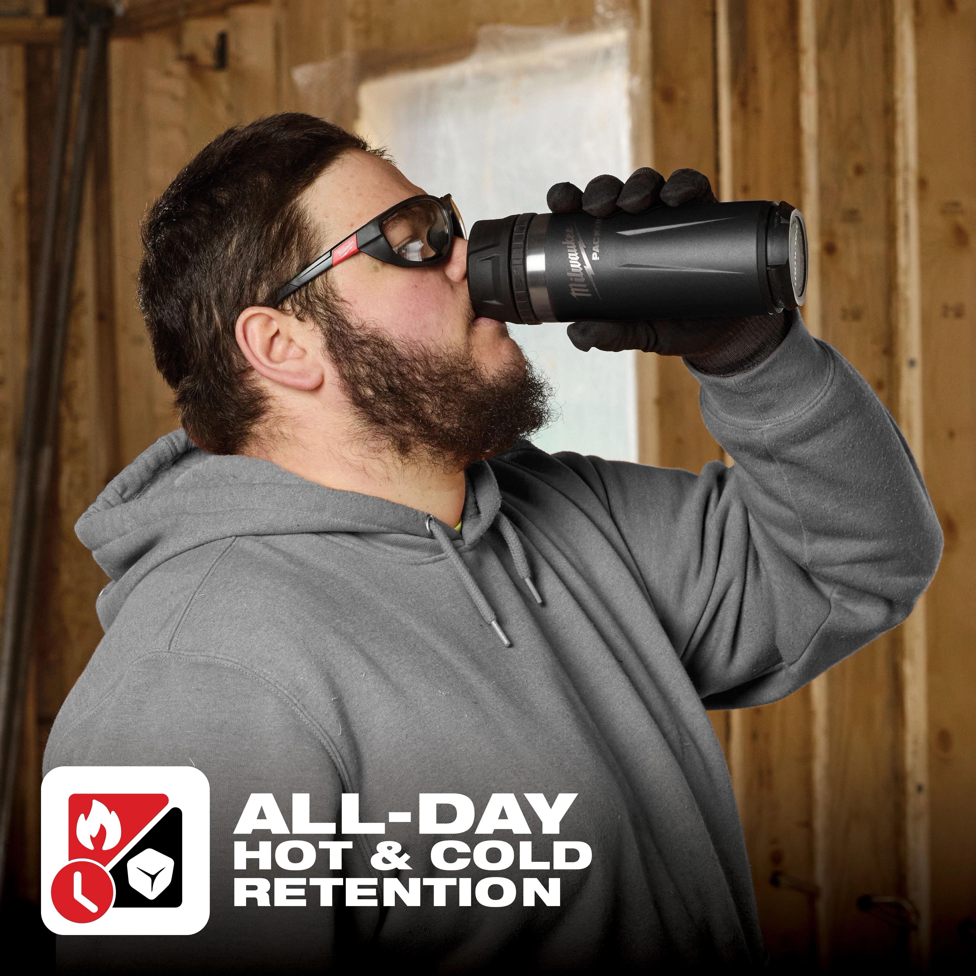 Person wearing gloves sipping from PACKOUT 18oz Insulated Bottle with Sip Lid. Text reads: "ALL-DAY HOT & COLD RETENTION".