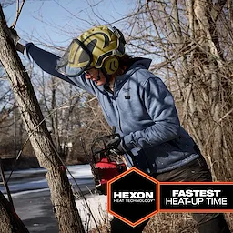 The M12™ Heated Hoodie is shown being worn by a person using a chainsaw outdoors in a wooded area. The hoodie features HEXON heat technology and provides the fastest heat-up time, depicted in text on the image. It is blue and has a front zipper and pockets.