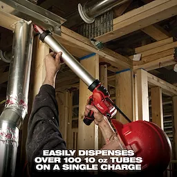 A person in a red hard hat uses a Milwaukee cordless caulking gun to seal a metal duct in a construction site. The caulking gun is capable of dispensing over 100 10 oz tubes on a single charge.