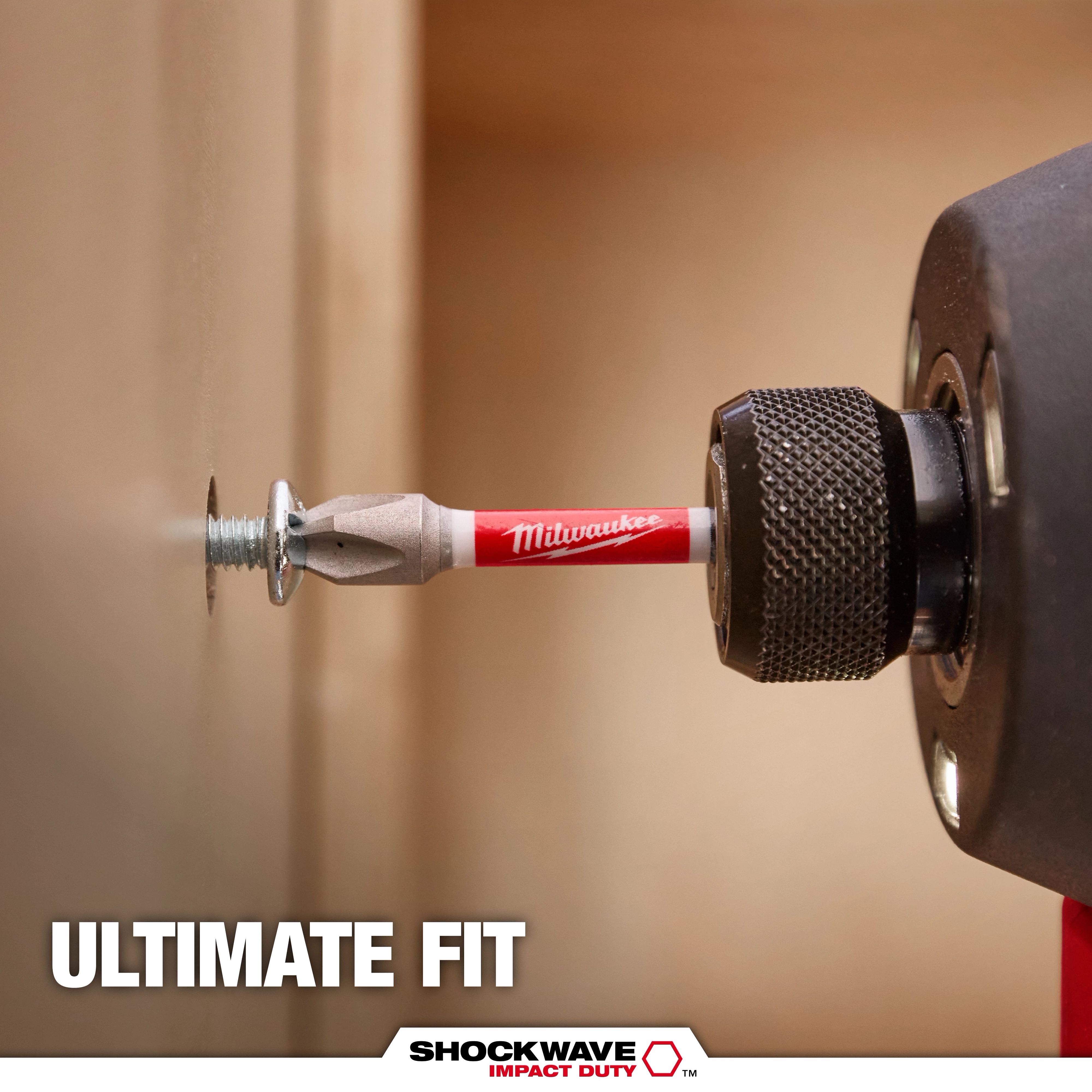 A SHOCKWAVE™ Philips Bit, branded by Milwaukee, is attached to a power drill driving a screw into a wooden surface. The text "ULTIMATE FIT" and the SHOCKWAVE™ logo with "IMPACT DUTY" appear at the bottom of the image.