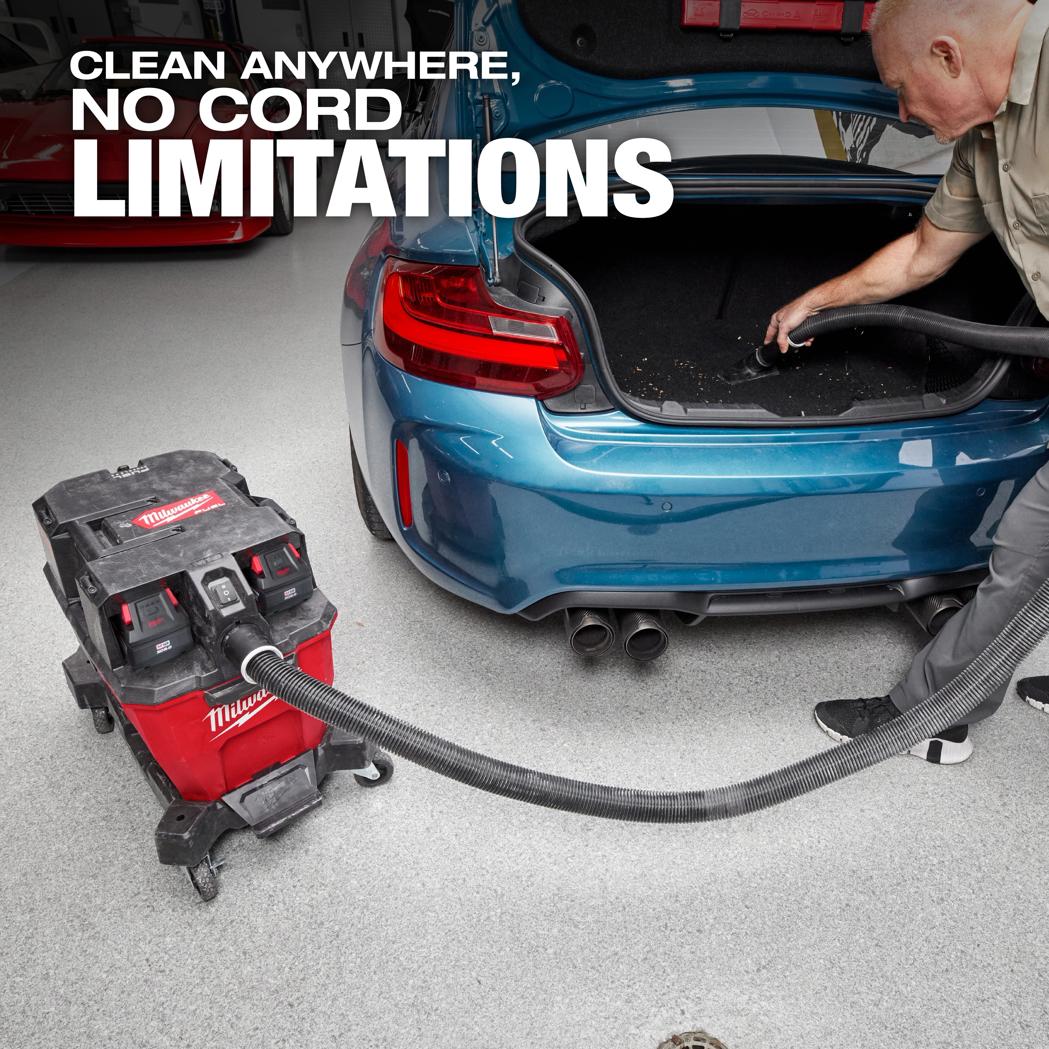 Milwaukee M18 FUEL™ NEXUS™ 9 Gallon Dual-Battery Wet/Dry Vacuum is used to clean the trunk of a blue car. The vacuum is red and black, placed next to the car, emphasizing its cordless functionality. Text overlay reads "Clean anywhere, no cord limitations."