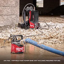 The image shows an MX FUEL™ 1HP 2" Submersible Pump in a construction setting, with the pump partially submerged in water and connected to a blue hose. In the background, there is a red and black portable pump power base (not included).