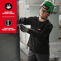 A person wearing a green safety helmet and gloves is working while dressed in a Women’s GRIDIRON™ Pocket T-Shirt - Long Sleeve. The t-shirt features moisture-wicking fabric and reinforced seams and hems as highlighted in the image.