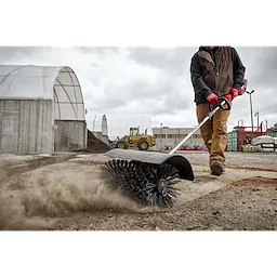 Worker using the M18 FUEL QUIK-LOK Bristle Brush Attachment