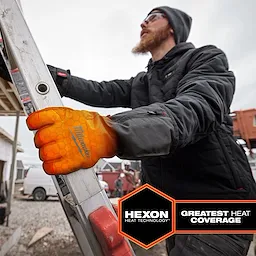 A person wears Heated Winter Gloves while climbing a ladder. The gloves are branded "Milwaukee" and feature Hexon Heat technology, providing the greatest heat coverage.