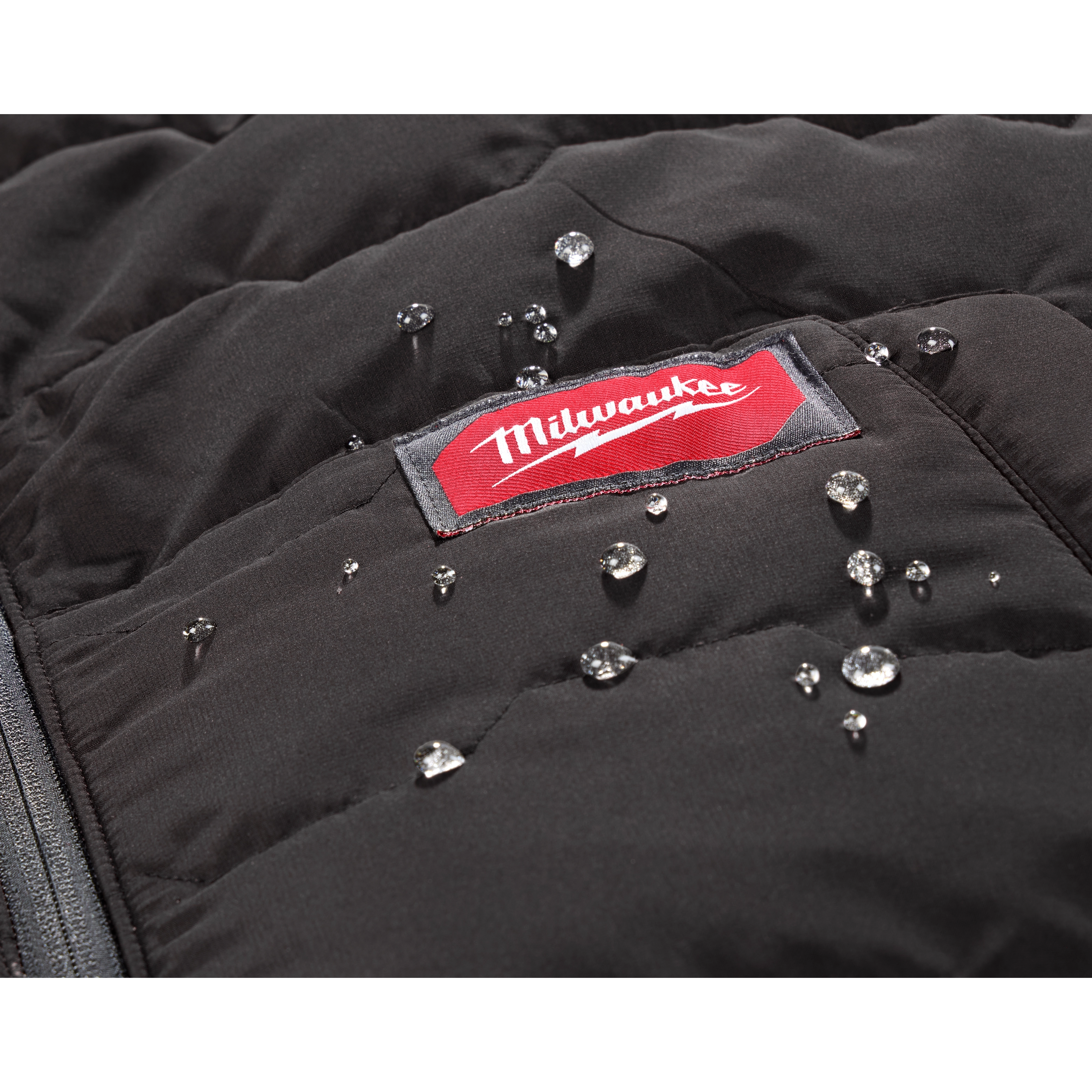 Close-up of the FREEFLEX™ Lightweight Insulated Vest showing water droplets on its black, stitched surface. The red and white Milwaukee logo is visible on the vest.