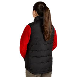 A woman with long brown hair in a ponytail is shown from the back wearing a black Women's FREEFLEX™ Lightweight Insulated Vest over a red long-sleeve shirt. The vest features a quilted pattern and a high collar.