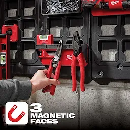 The PACKOUT Magnetic Rack is mounted on a black panel, holding red pliers and other tools. It features three magnetic faces.