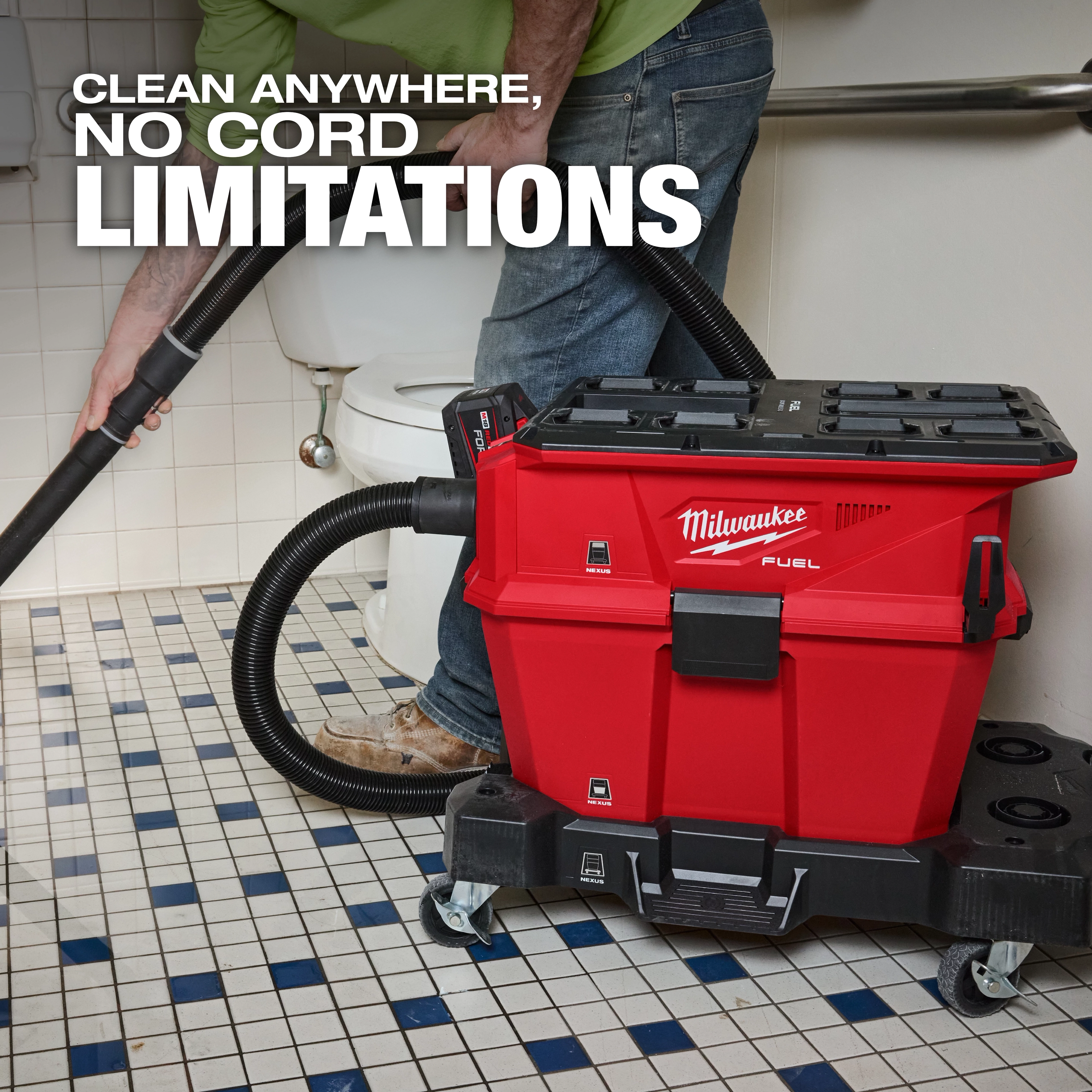 A person uses the Milwaukee M18 FUEL NEXUS 6 Gallon Wet/Dry Vacuum with PACKOUT Compatibility in a bathroom. The red vacuum, equipped with a flexible hose, is cordless and positioned on casters. Text on the image says "Clean anywhere, no cord limitations."
