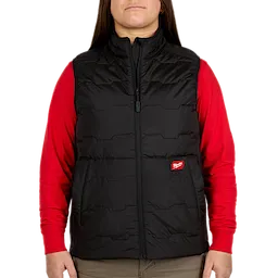 A woman is wearing a Women's FREEFLEX™ Lightweight Insulated Vest. The black vest has a front zipper and the Milwaukee brand logo on the left side. She is also wearing a red long-sleeve shirt underneath.