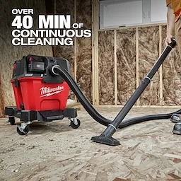 The image features the M18 FUEL™ NEXUS™ 6 Gallon Wet/Dry Vacuum, shown in a construction setting. A person operates the vacuum, demonstrating over 40 minutes of continuous cleaning. The vacuum is red with black attachments and wheels, branded with the Milwaukee logo.