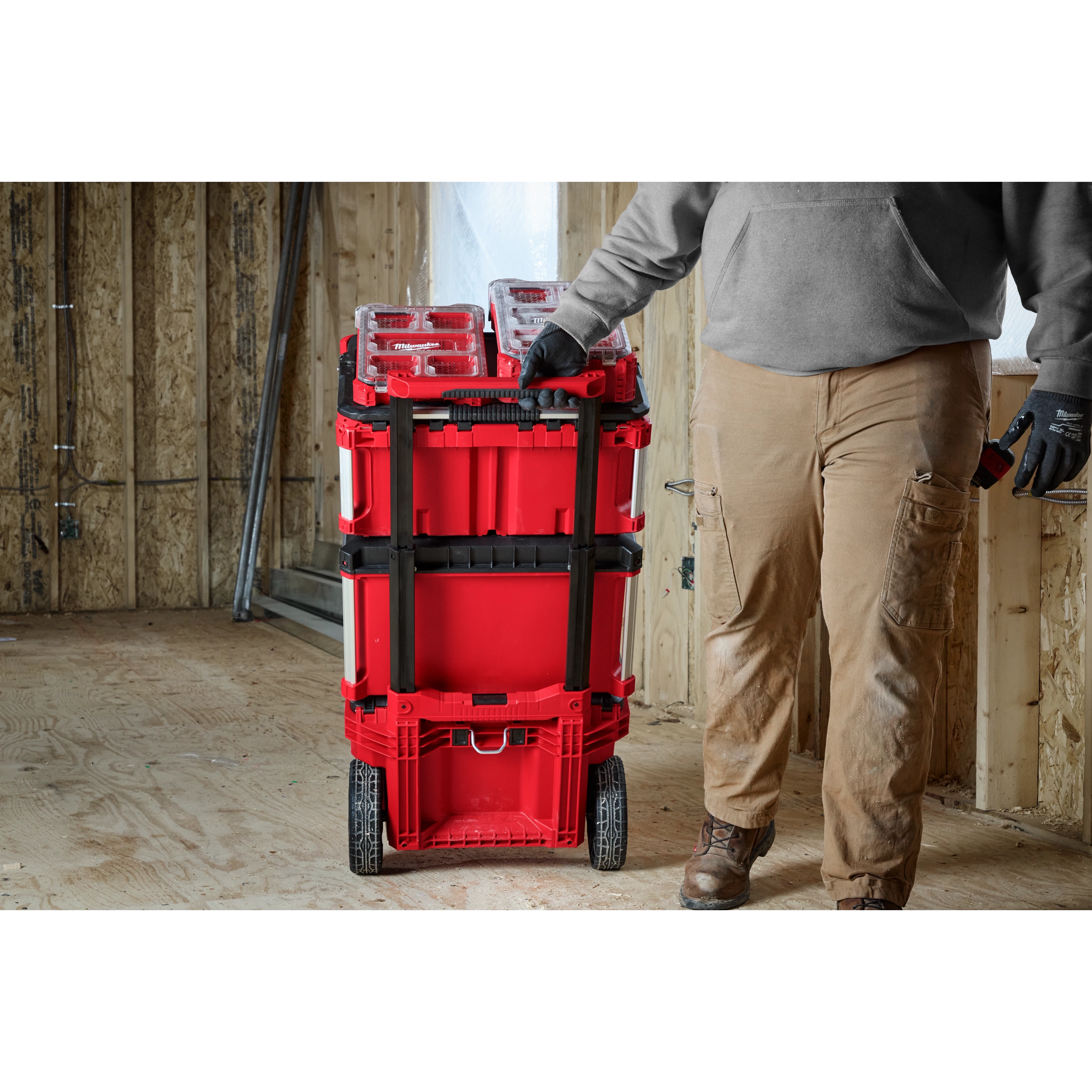 Image of the Milwaukee PACKOUT Rolling Tool Box with Low-Profile Handle being used by a worker on a jobsite