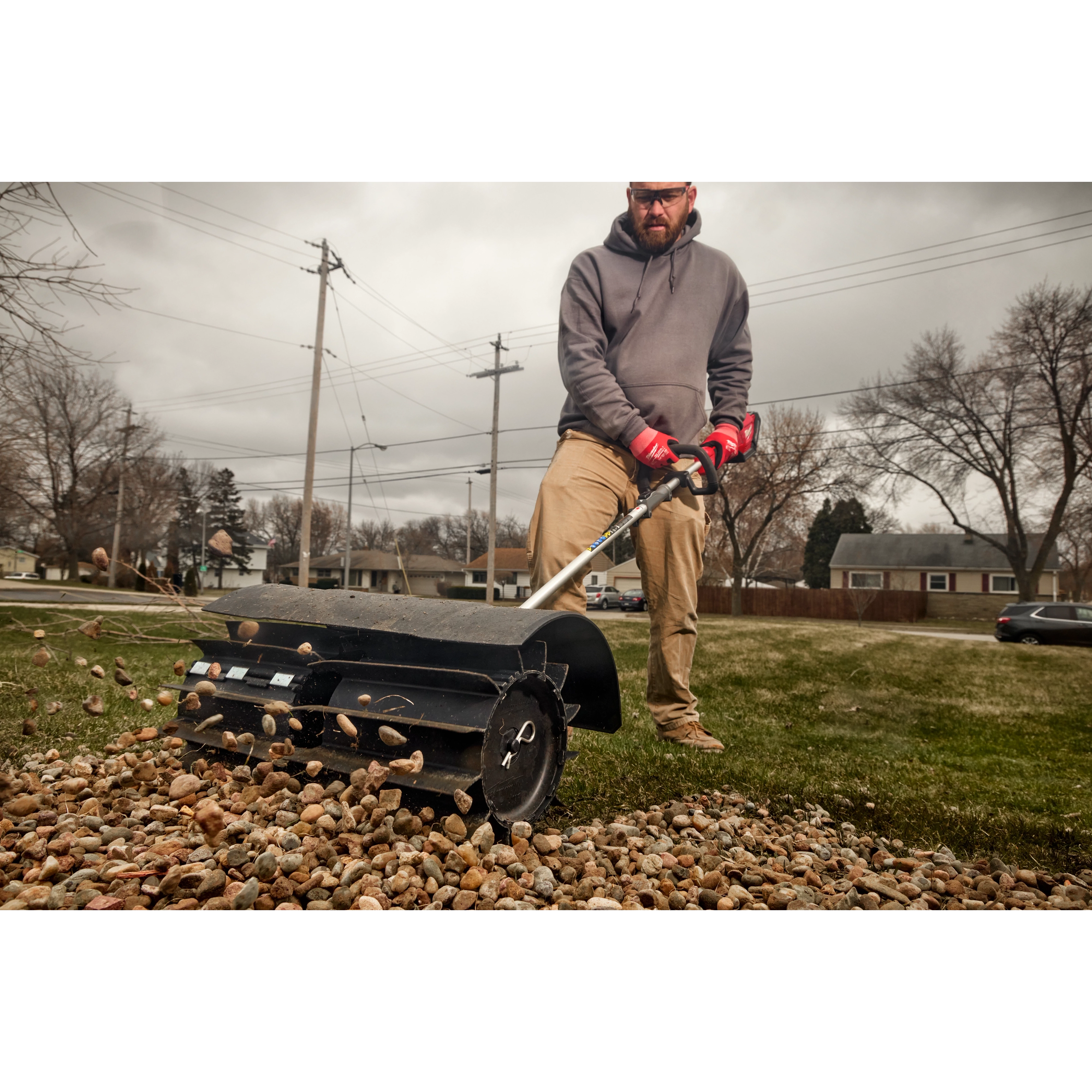 Worker using the M18 FUEL QUIK-LOK Rubber Broom Attachment