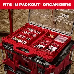 The image shows a Milwaukee PACKOUT organizer box opened to reveal various SHOCKWAVE™ fits in PACKOUT™ drill and driver bits neatly arranged inside. The container sits on top of other PACKOUT units, demonstrating its compatibility and storage capacity.