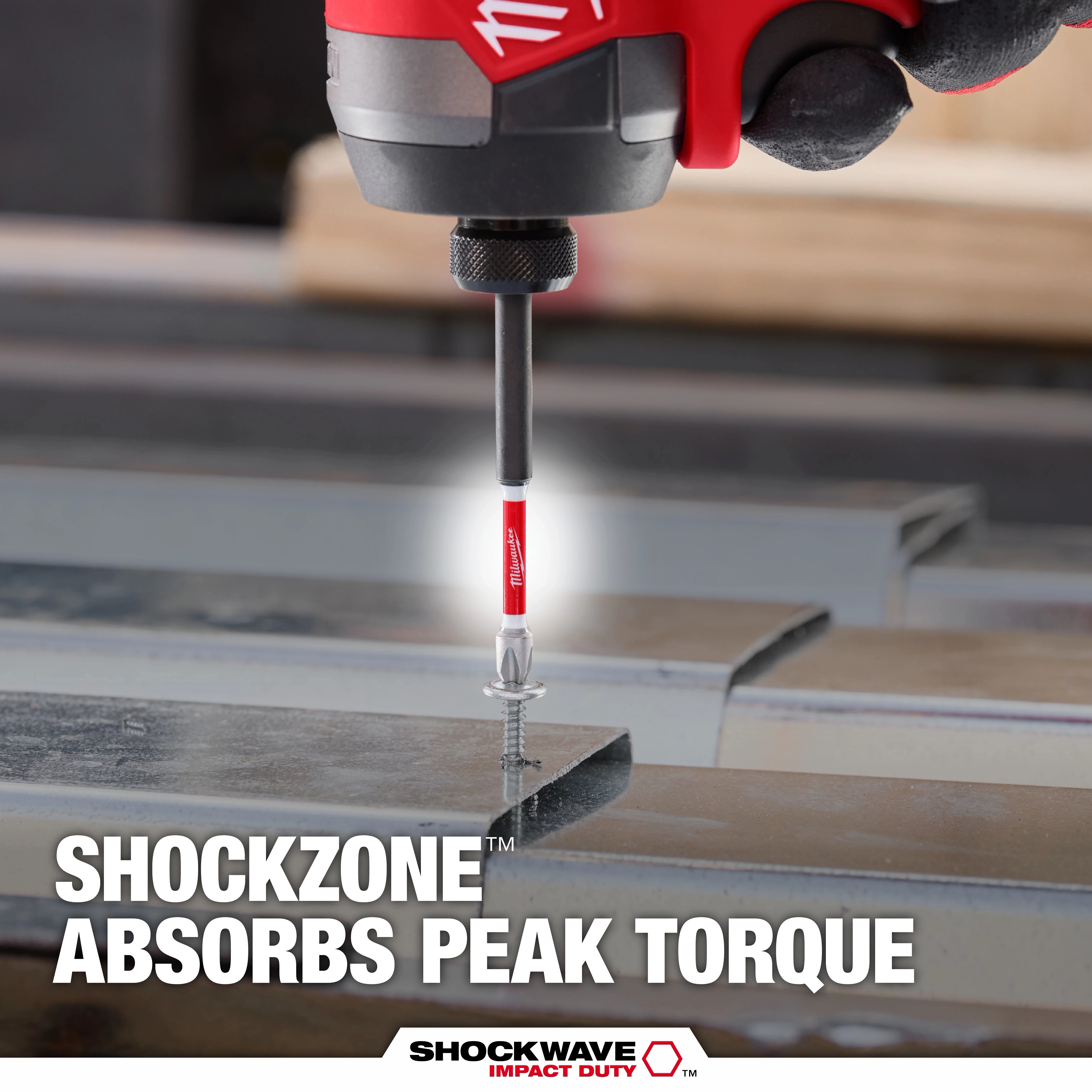 The image shows a SHOCKWAVE™ SHOCKZONE™ Philips Bit being used with a power tool to drive a screw into metal. Text on the image highlights that the SHOCKZONE™ technology absorbs peak torque, enhancing durability. The product branding "SHOCKWAVE IMPACT DUTY™" is visible at the bottom.