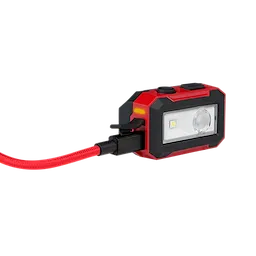 The Milwaukee® Rechargeable Magnetic Headlamp and Task Light features a rectangular, red and black body with a front-facing LED light and a red cable attached. It has two black buttons on top and a magnetic base for mounting.
